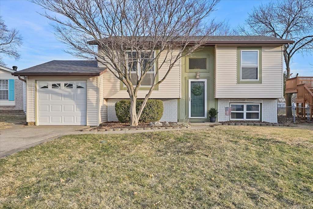 raised ranch with a garage and a front lawn