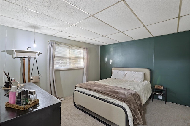 bedroom with a paneled ceiling and carpet