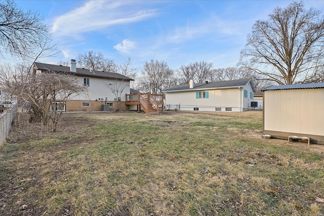 view of yard with cooling unit, a deck, and a shed