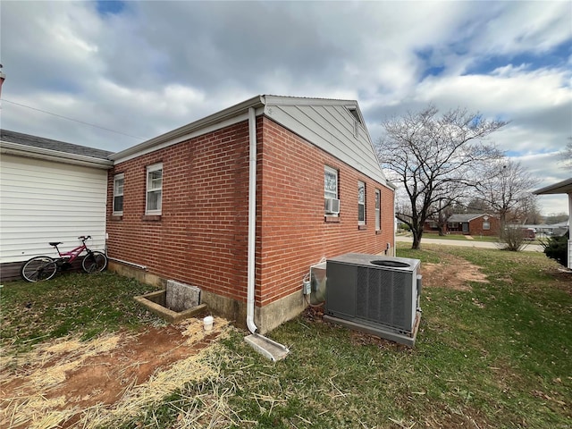 view of side of property with a lawn and central air condition unit