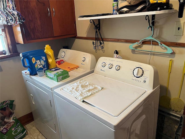 clothes washing area with cabinets and washing machine and clothes dryer