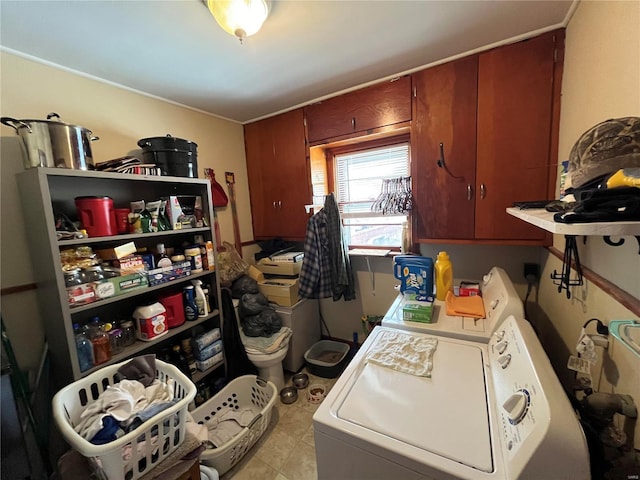 laundry area featuring washer and dryer, light tile patterned floors, and cabinets