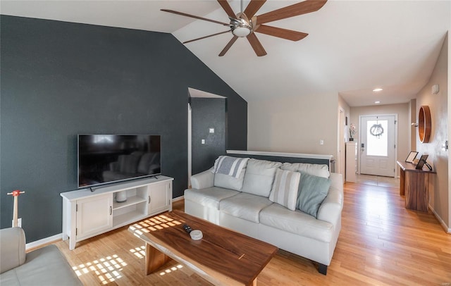 living room featuring ceiling fan, vaulted ceiling, and light wood-type flooring