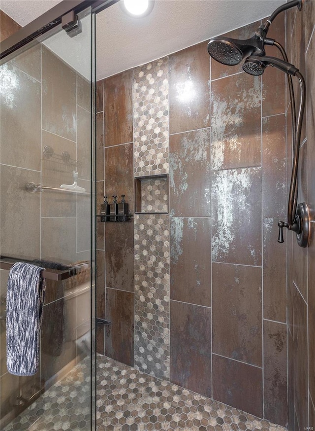 bathroom with a shower with door and a textured ceiling