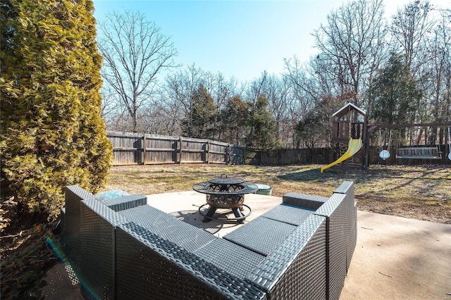 view of patio with a playground and an outdoor fire pit