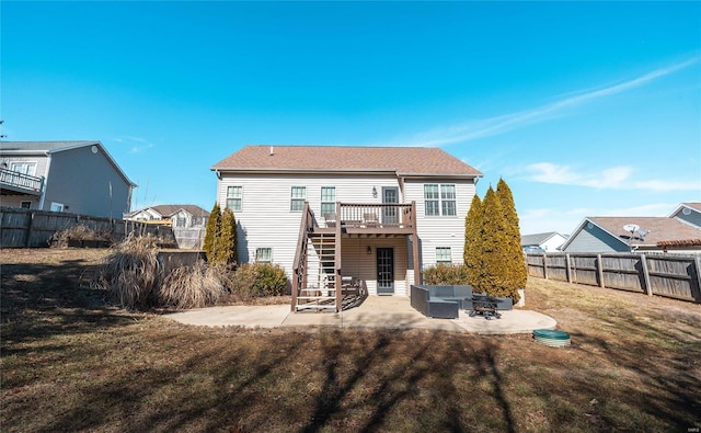 back of property featuring a lawn, a wooden deck, an outdoor living space with a fire pit, and a patio area