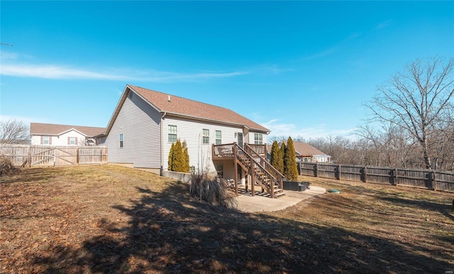 rear view of house with a deck, a patio area, and a lawn