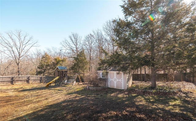 view of yard featuring a playground and a storage shed