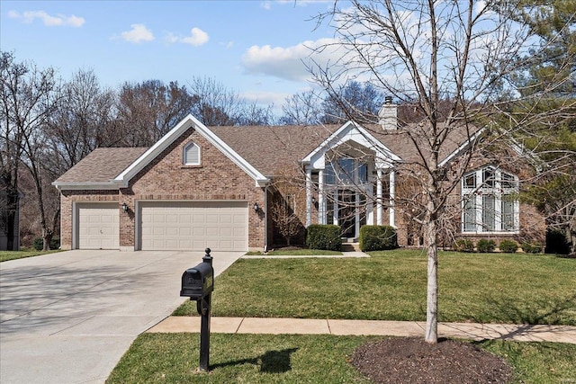 view of front facade featuring brick siding, a front lawn, a chimney, driveway, and an attached garage