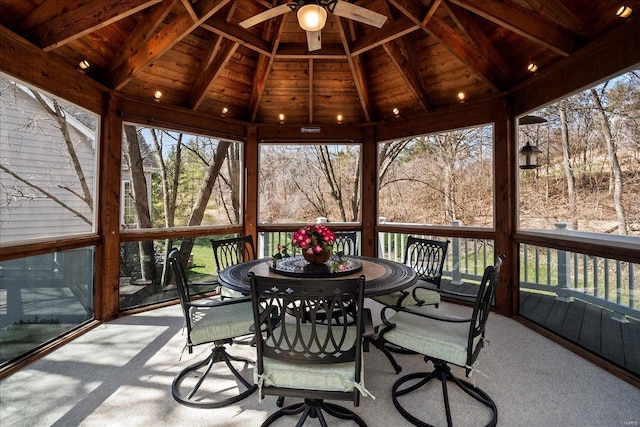 sunroom featuring wooden ceiling, lofted ceiling with beams, and a ceiling fan