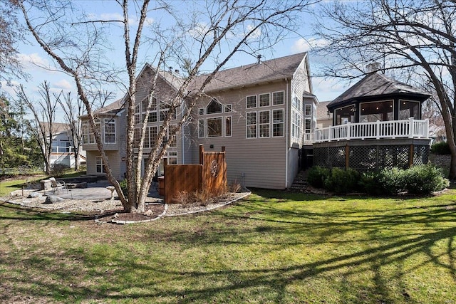 rear view of house with stairway, a deck, a yard, and a sunroom