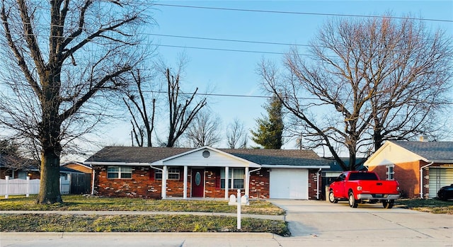 view of front of house featuring concrete driveway, brick siding, and fence