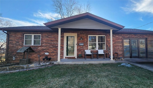 rear view of property featuring a lawn and a patio area