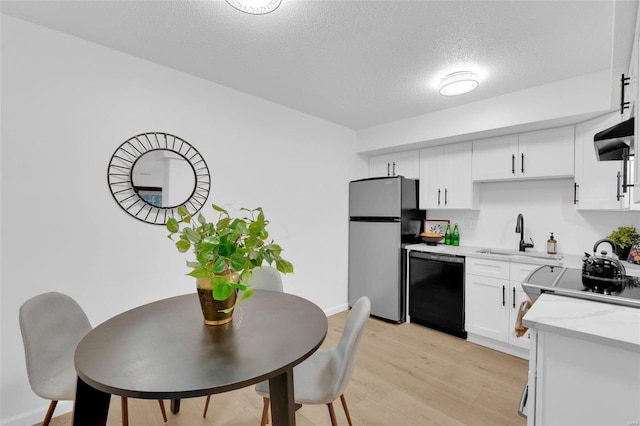 kitchen featuring sink, stainless steel fridge, light hardwood / wood-style flooring, dishwasher, and white cabinetry