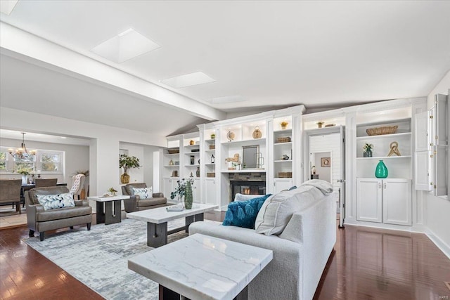 living room featuring a chandelier, a glass covered fireplace, vaulted ceiling with beams, and dark wood-type flooring