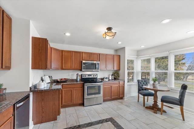 kitchen with recessed lighting, brown cabinetry, baseboards, and appliances with stainless steel finishes