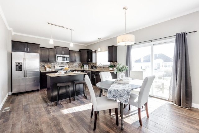 dining space featuring crown molding, dark hardwood / wood-style flooring, and sink