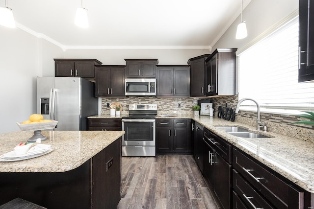 kitchen with crown molding, appliances with stainless steel finishes, sink, and hanging light fixtures