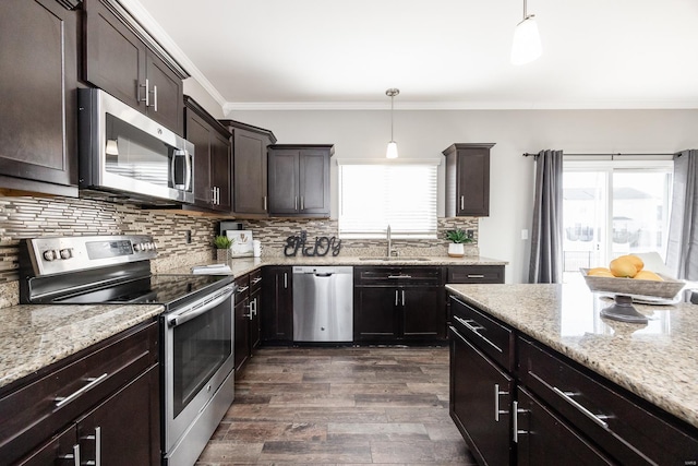 kitchen with hanging light fixtures, appliances with stainless steel finishes, sink, and dark brown cabinets