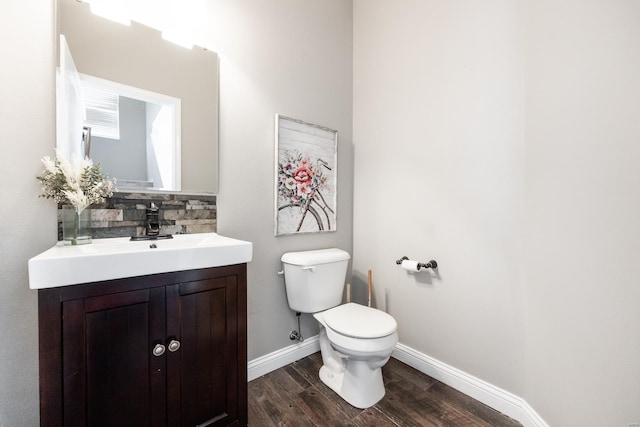 bathroom with hardwood / wood-style flooring, vanity, toilet, and tasteful backsplash