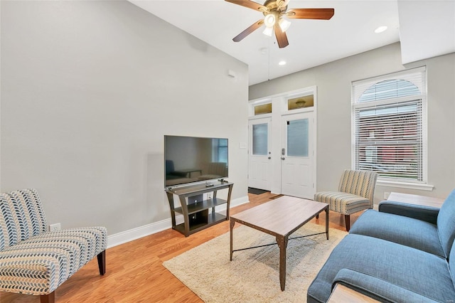 living room with ceiling fan and light hardwood / wood-style flooring