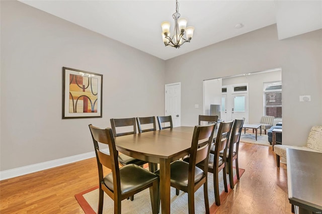 dining area with wood-type flooring and a notable chandelier