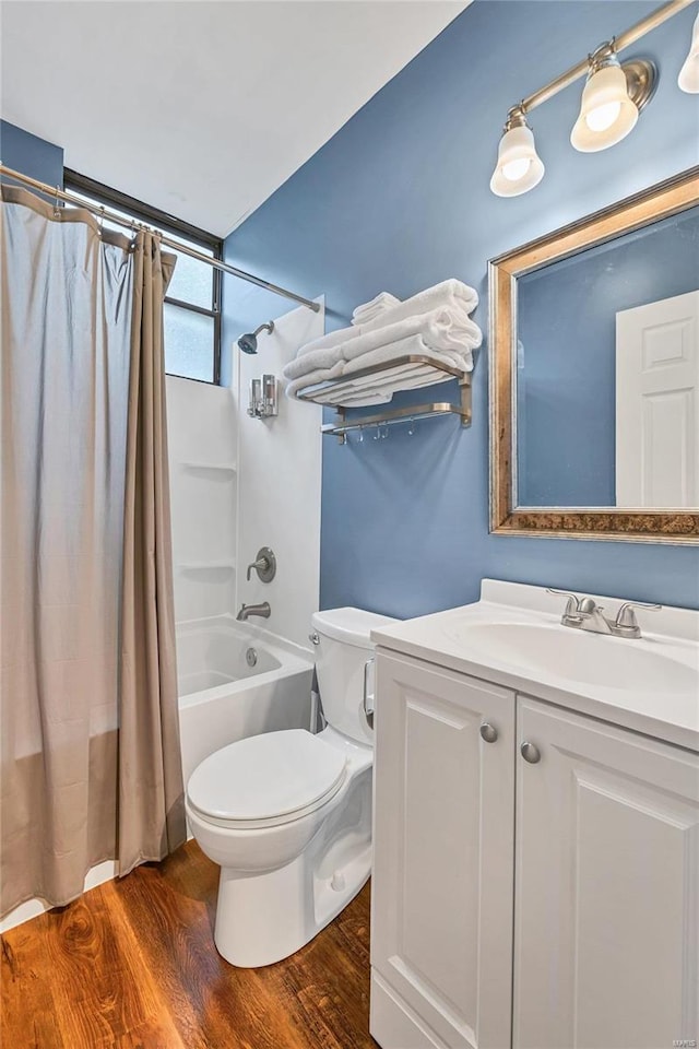 full bathroom featuring hardwood / wood-style flooring, shower / tub combo with curtain, vanity, and toilet