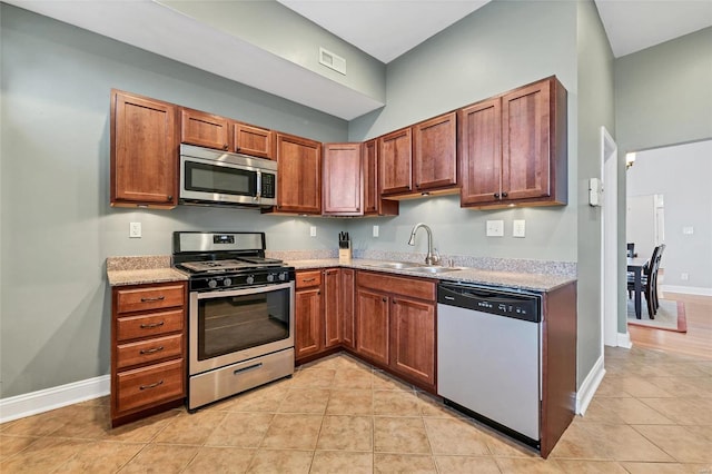 kitchen with appliances with stainless steel finishes, sink, and light tile patterned floors