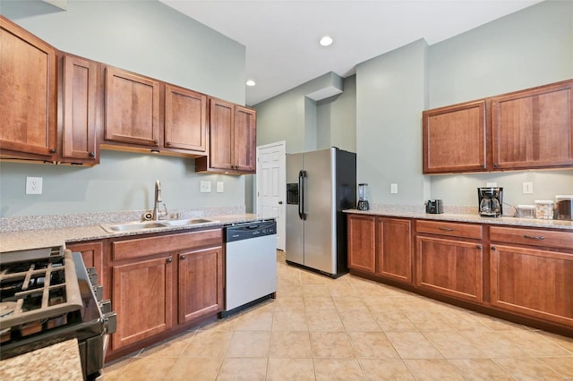 kitchen with light stone counters, sink, light tile patterned floors, and stainless steel appliances