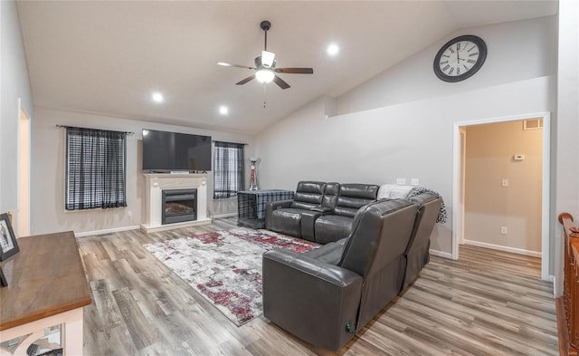 living room with ceiling fan, high vaulted ceiling, and light hardwood / wood-style flooring