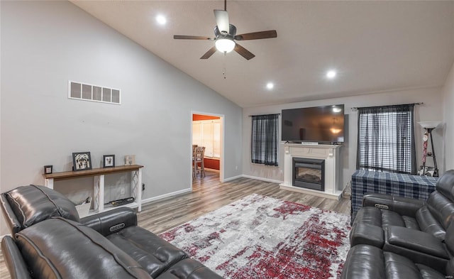 living room with hardwood / wood-style flooring, high vaulted ceiling, and ceiling fan