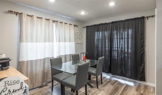 dining area featuring hardwood / wood-style flooring and a textured ceiling