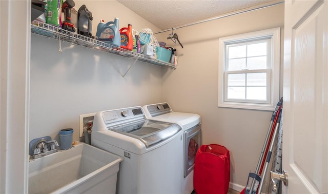 laundry room featuring separate washer and dryer, sink, and a textured ceiling