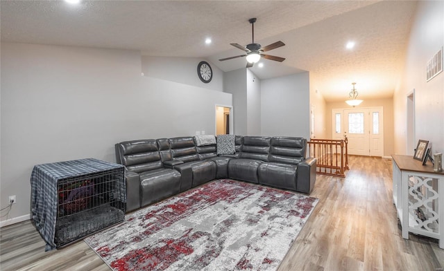 home theater room with wood-type flooring, high vaulted ceiling, ceiling fan, and a textured ceiling