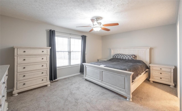 bedroom featuring ceiling fan, light colored carpet, and a textured ceiling