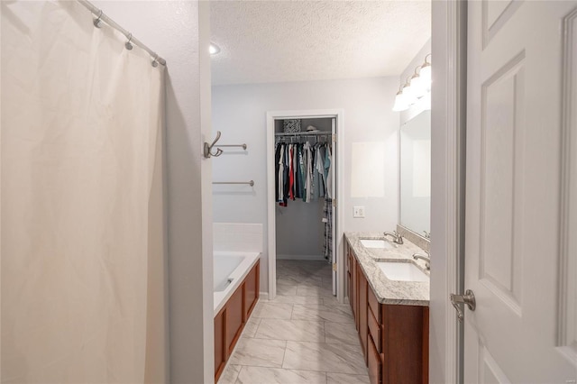 bathroom with vanity, separate shower and tub, and a textured ceiling