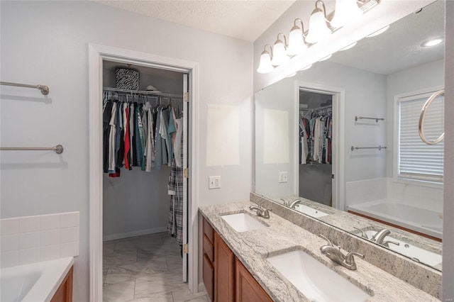 bathroom with vanity, a bathing tub, and a textured ceiling