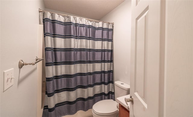 bathroom with vanity, toilet, curtained shower, and a textured ceiling