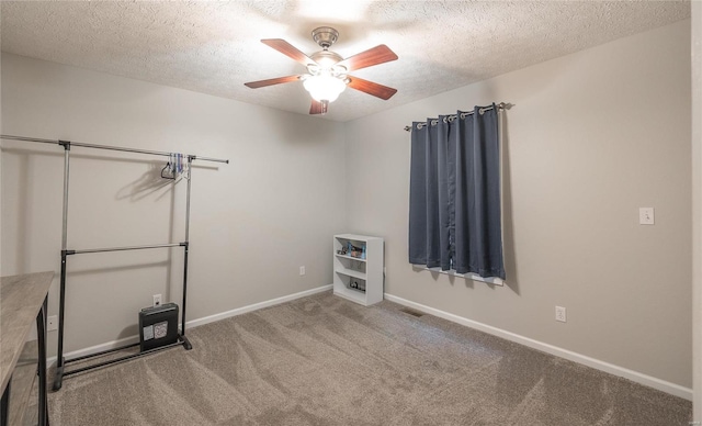 spare room with ceiling fan, a textured ceiling, and carpet flooring