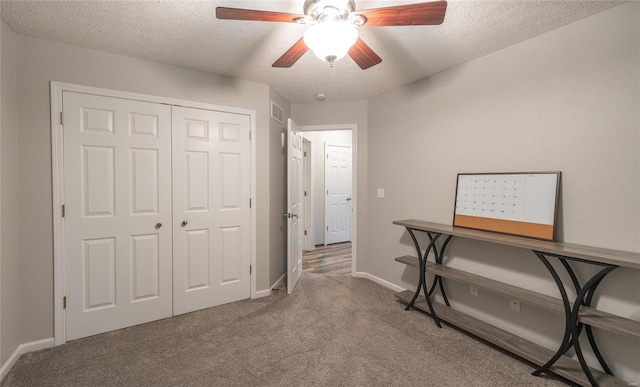 office area featuring ceiling fan, carpet, and a textured ceiling