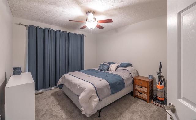 bedroom with ceiling fan, light carpet, and a textured ceiling