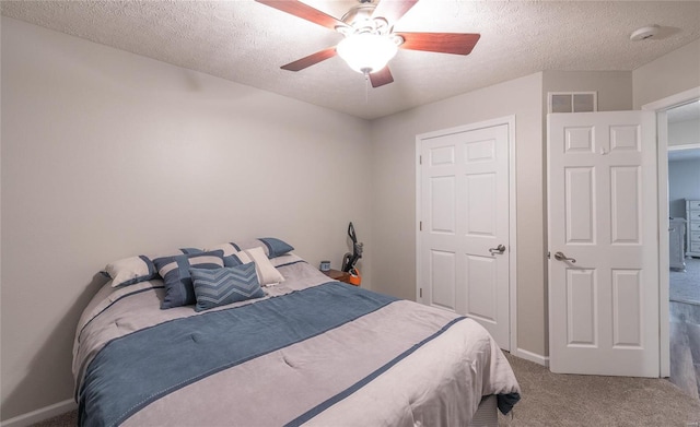 bedroom featuring ceiling fan, carpet flooring, and a textured ceiling