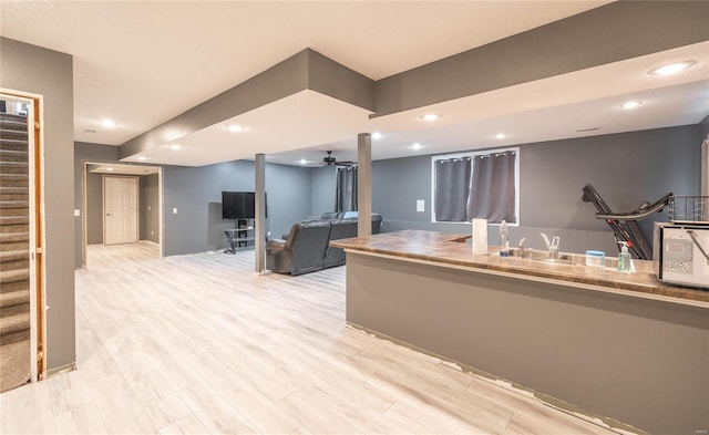 kitchen with ceiling fan, sink, and light wood-type flooring