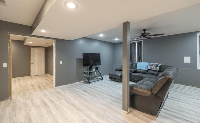 living room with light hardwood / wood-style floors and ceiling fan