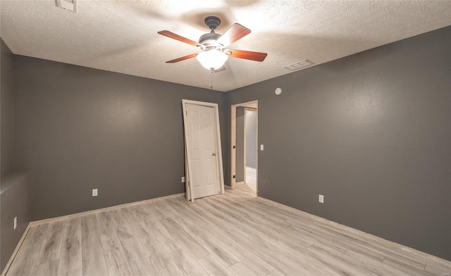 spare room featuring ceiling fan, a textured ceiling, and light hardwood / wood-style floors