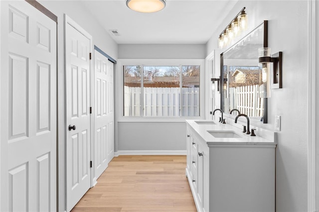 clothes washing area featuring sink and light hardwood / wood-style floors