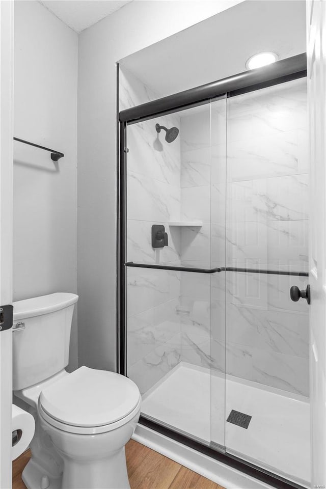 bathroom featuring hardwood / wood-style floors, toilet, and walk in shower