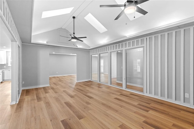 unfurnished living room with ceiling fan, high vaulted ceiling, a skylight, and light hardwood / wood-style floors