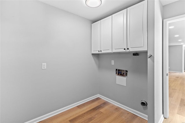 laundry room featuring cabinets, washer hookup, and light hardwood / wood-style floors