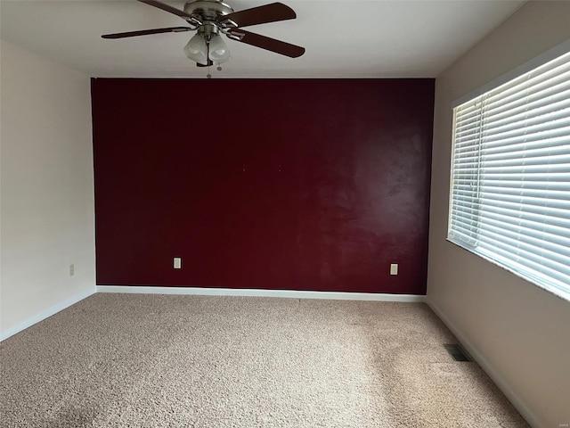 carpeted spare room with ceiling fan